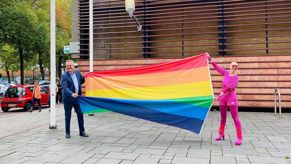 Foto van Renske Claas en Henk ten Hulscher die een regenboogvlag vasthouden